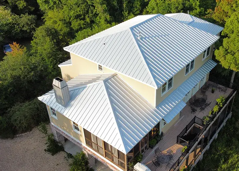 Aerial shot of a Gulf Coast home with a light color standing seam metal roof